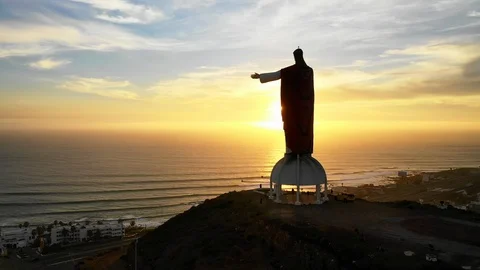 Aerial Descend-Large Jesus Statue Overlooking Town By Sea At Sunset in Baja Stock Footage