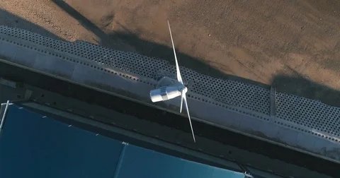 Aerial descending close up view of a wind turbine on the beach Stock Footage 78606002