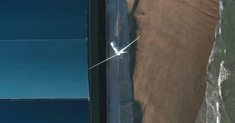 Aerial descending close up view of a wind turbine on the beach Stock Footage 79653945