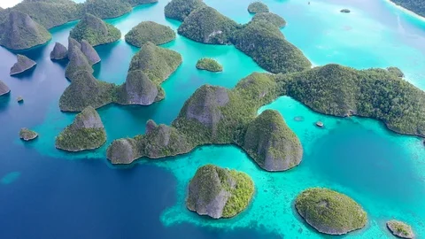 Aerial Descending over Limestone cliffs and coral reefs in incredible Wayag, Raj Stock Footage 104385439