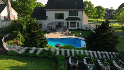 Aerial descending push in of pool in backyard of expensive American home. Stockbeeldmateriaal 195977214