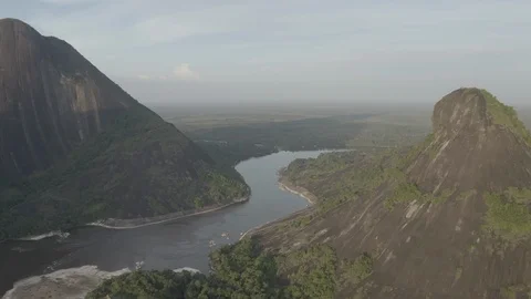 Aerial descends between the Cerros de Mavecure over the Inirida river Vídeos de archivo 100799987