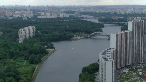 Aerial descent over river with bridge and buildings 库存影片 332735544