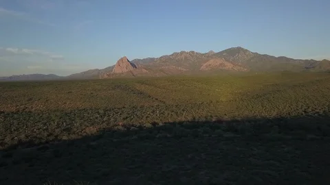 Aerial of a desert mountain range and prominent rock formation Stock Footage 95159005