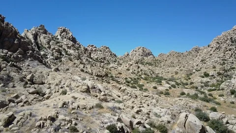 Aerial, desolate rock outcroppings &amp; pointed mountains, arid California desert Stock Footage 114086980