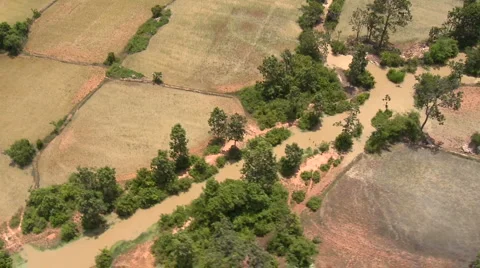 Aerial of different rural fields with river flowing through low altitude Stock Footage
