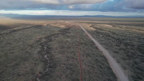Aerial of a dirt road going through a vast valley with a speeding pickup truck Stock Footage 237019720