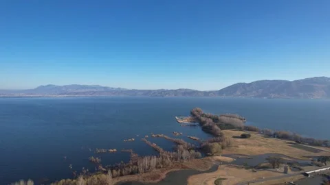 Aerial distant view of shallow beach wetland wide lake mountain scenery in Dali Video stock 337922400