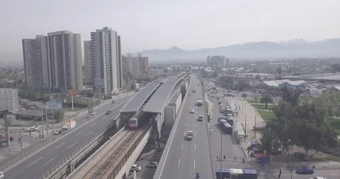 AERIAL DOLLY BACK OF TRAIN METRO SUBWAY WITH VIEW OF THE CITY AND MOUNTAINS 4K Stock Footage 101334021