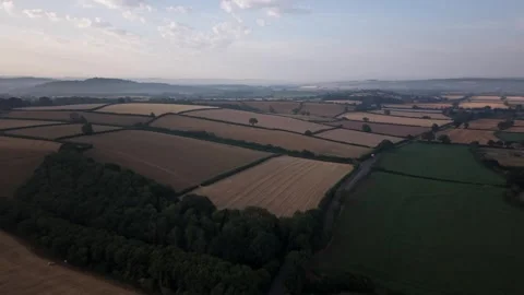 Aerial Dolly Backward over Patchwork Farmland and Woodland Stock Footage 347979089