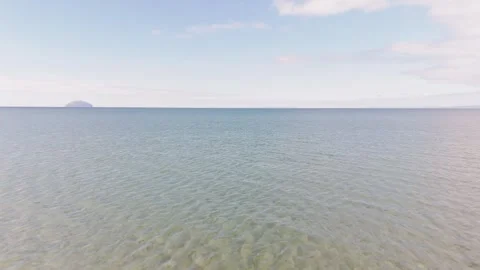 Aerial dolly forward over rippling ocean water and Ailsa Craig island background Vídeos de archivo 333956455