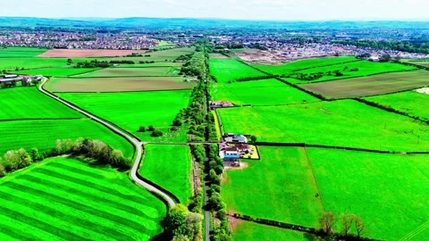 Aerial Dolly Forward Over Scottish Farmland Toward Rural Settlement Video stock 336675431