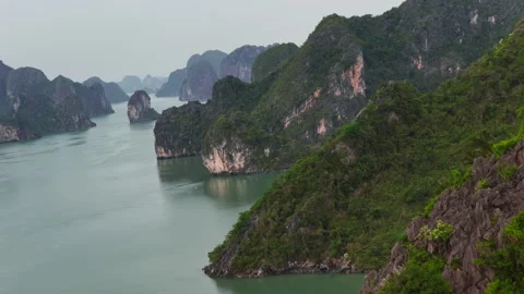 Aerial Dolly In High Angle Of Lush Limestone Karst Cliffs And Emerald Water Ha Stockbeeldmateriaal 335122561
