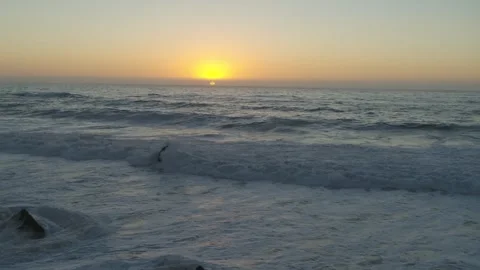 Aerial dolly looking at the sunset over the ocean Stock Footage 244936784