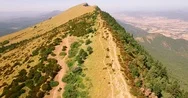 Aerial Dolly Out Drone Shot At Person Walking On Top Of Mountain Stock Footage
