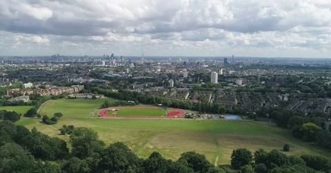 Aerial dolly view of the skyline of central London from a park Stock Footage 79099281