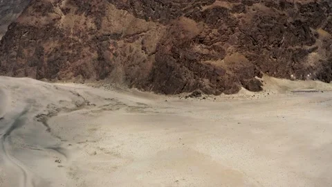 Aerial dolly onto a white car parked in a desert with mountains, Skardu Pakistan Stock Footage 131822053