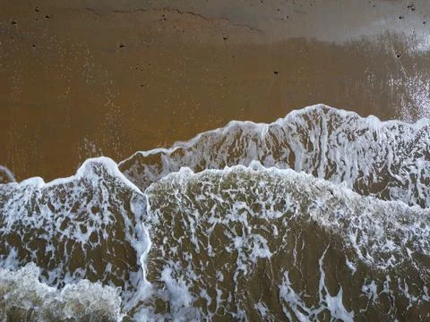 Aerial down view of whit waves washing on the beach Stock Photos