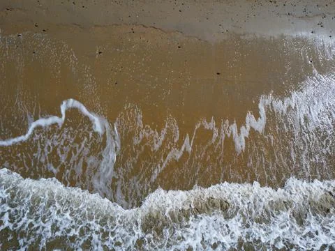 Aerial down view of white waves washing on the beach Stock Photos