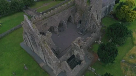 Aerial down to the yard of Gowran ancient irish church i Stock Footage 202741252