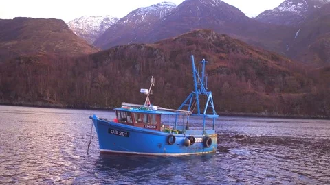 Aerial: Dramatic Aonach Eagach ridge (Glen Coe) with fishing boat. Scotland. 4K Stock Footage 103183927