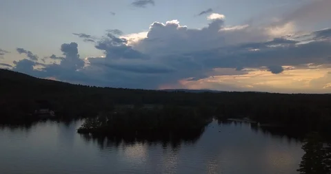 Aerial dramatic clouds at sunset over a peaceful lake and tiny island Stock Footage 111522837