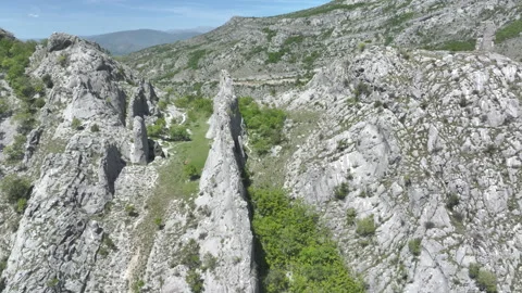 AERIAL: Dramatic limestone ridge cutting through lush greenery in Blagaj, Bosnia Stock Footage 302653251