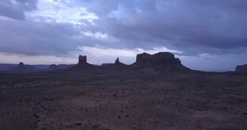 Aerial: dramatic storm clouds as we fly up and into Monument Valley Stock Footage 100610297