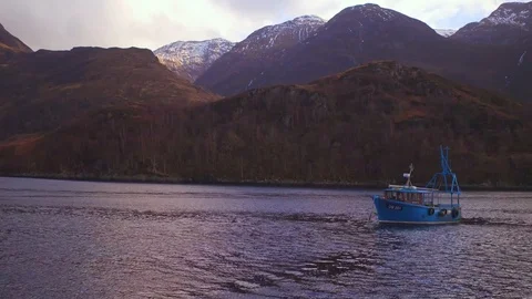 Aerial: Dramatic view of Aonach Eagach ridge and fishing boat. Scotland. 4K Stock Footage 103184608