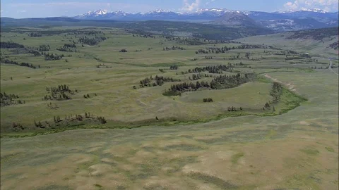 Aerial of dried river bed through rolling hills covered with grass, Calm green Stock Footage 109465856