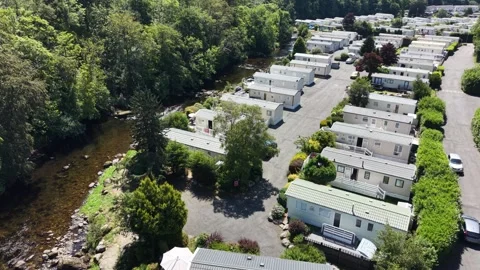 Aerial drone 4K view of caravan area surrounded by meadow landscape Wales Video stock 339737536