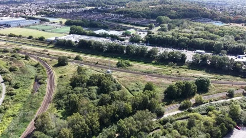 Aerial drone 4K view of Merseyside rail line glowing in warm afternoon sky Stock Footage 343157685
