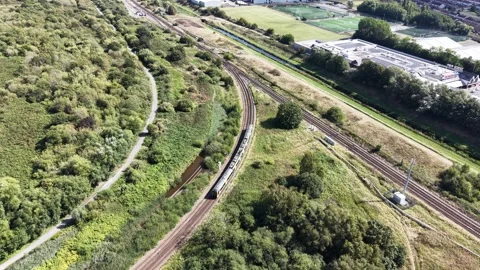 Aerial drone 4K view of Merseyside train moving across warm daylight terrain Stock Footage 343158205