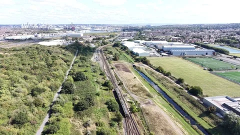 Aerial drone 4K view of Merseyside rail line with train glowing in warm sunlight Stock Footage 343158666