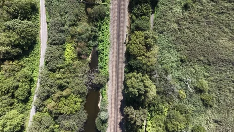 Aerial drone 4K view of Merseyside rail line running through warm afternoon Stock Footage 343159358