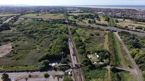 Aerial drone 4K view of Merseyside train crossing warm sunlit tracks Merseyside Stock Footage 343160722