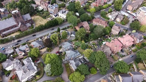 Aerial drone 4K view of Wirral neighbourhood rooftops glowing in warm daylight Video stock 342287172