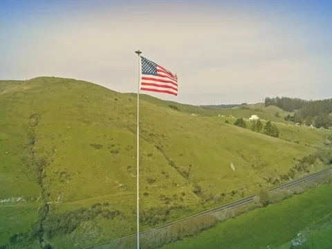 Aerial drone of american flag waving on top of a hill Stock Footage
