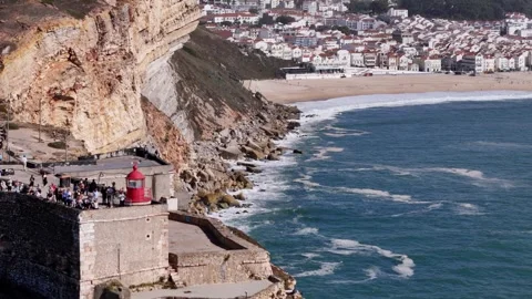 Aerial drone approaching the stunning cliffs and famous lighthouse at Nazare Stock Footage 287731352