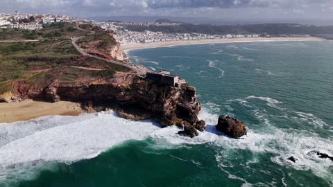 Aerial drone approaching the stunning cliffs and famous lighthouse at Nazare Stock Footage 287732456