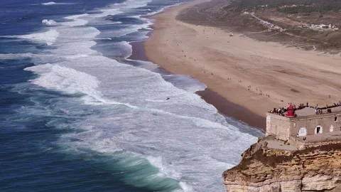 Aerial drone approaching the stunning cliffs and famous lighthouse at Nazare Stock Footage 287732542