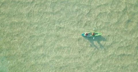 Aerial drone ascending spin of 2 people man and woman in kayak on lake Stock Footage 108725048