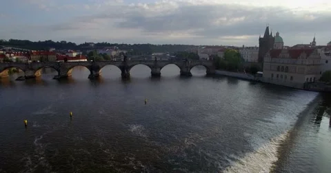 Aerial drone camera tracks backwards and low from the Charles bridge in Prague Stock Footage 65718896