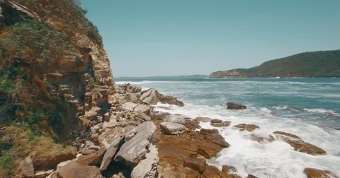 Aerial Drone camera view flying forward rocky ocean beach cliff waves daylight Stock Footage 73619395