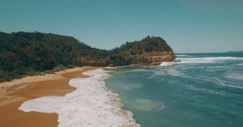 Aerial Drone camera view of a sandy beach cliff point waves shoreline daylight Stock Footage 73622705