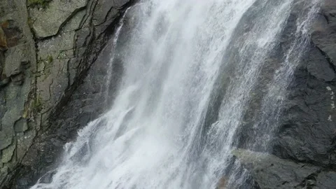 Aerial drone closeup of river stream waterfall flowing on green rocky mountain Stock Footage 215877751
