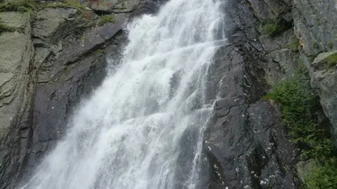 Aerial drone closeup of river stream waterfall flowing on green rocky mountain Stock Footage 215878569