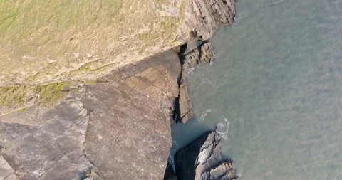 Aerial Drone Down over Devon rocks cliffs and sea United Kingdom Stock Footage 88251267