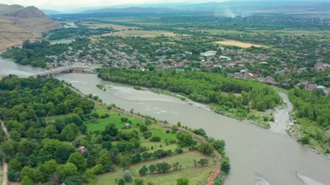Aerial drone flies forward above the Kura River near Uplistsikhe, Georgia Stock Footage 340765367