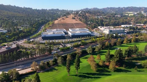 Aerial drone flies forward over Universal Studios soundstages next to a golf Video stock 343616518